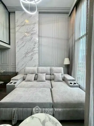 Luxurious modern living room with elegant gray sofa and marble accents