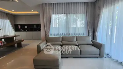 Spacious modern living room with elegant sofa and large windows