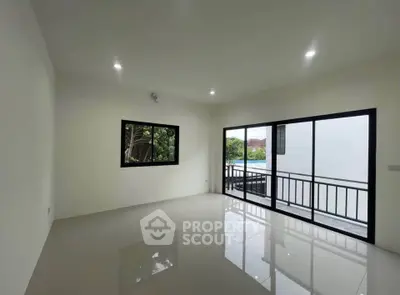 Spacious modern living room with large windows and balcony access