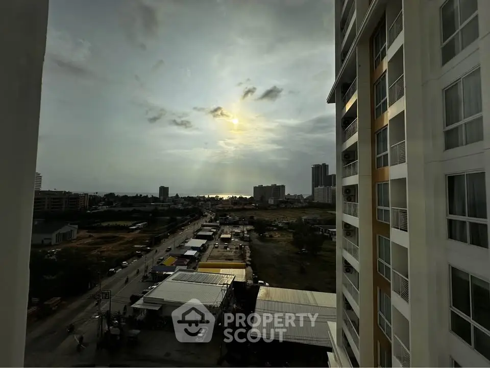 Stunning urban view from high-rise building at sunset, showcasing cityscape and distant horizon.