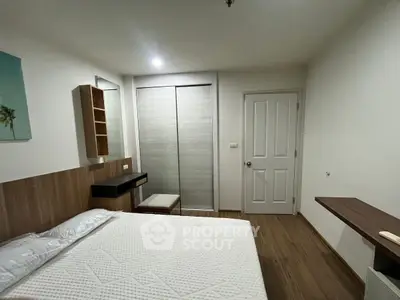 Modern bedroom with wooden flooring and built-in wardrobe in a cozy apartment.