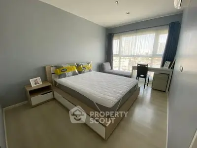 Modern bedroom with large window and stylish decor in a high-rise apartment.