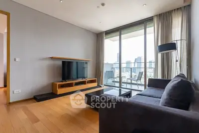 Modern living room with sleek furniture and city view balcony in luxury apartment.