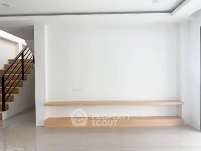 Modern minimalist interior with wooden shelves and staircase, perfect for stylish living.