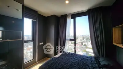 Modern bedroom with large windows offering stunning city views