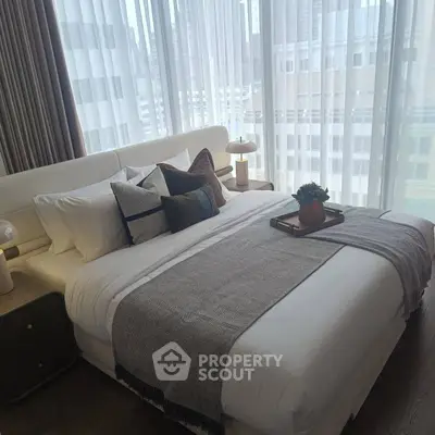 Luxurious bedroom with elegant decor and city view, featuring plush bedding and stylish accents.