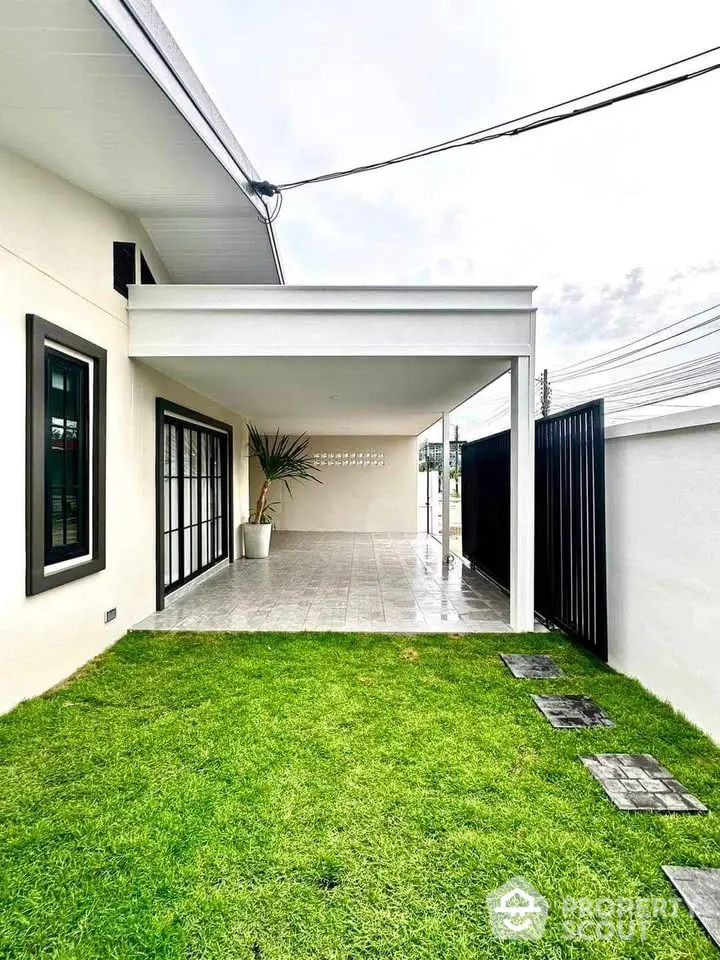 Charming modern home exterior with lush green lawn and spacious covered patio.