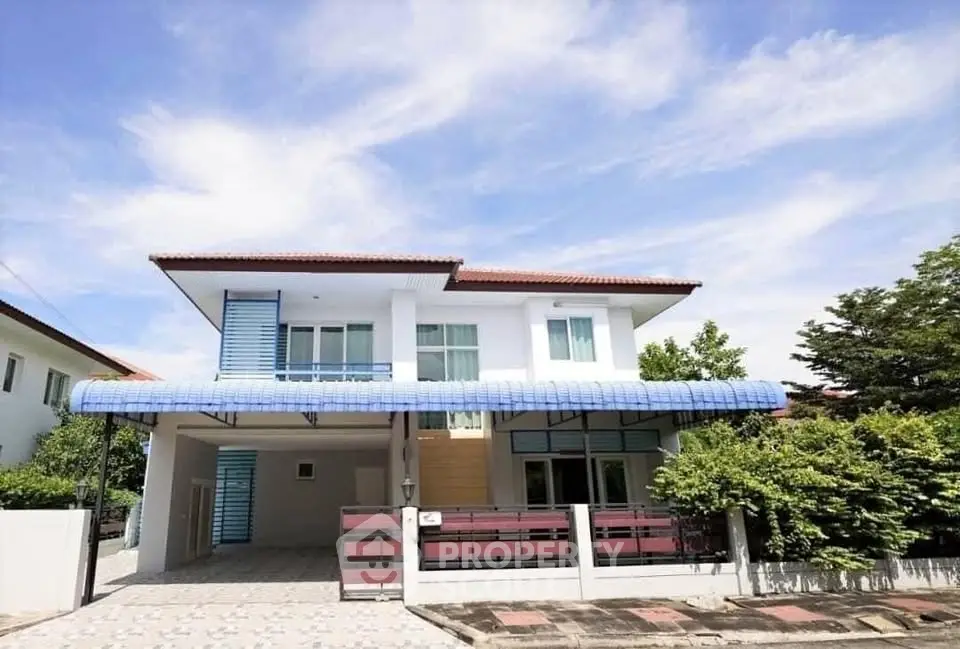 Charming two-story house with spacious driveway and lush greenery, perfect for family living.