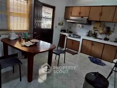Cozy kitchen with wooden cabinets and dining area, perfect for family meals.
