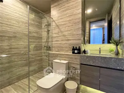 Luxurious modern bathroom with elegant stone tiles and glass shower enclosure