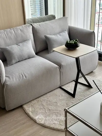 Modern living room with stylish gray sofa and sleek side table, perfect for urban living.