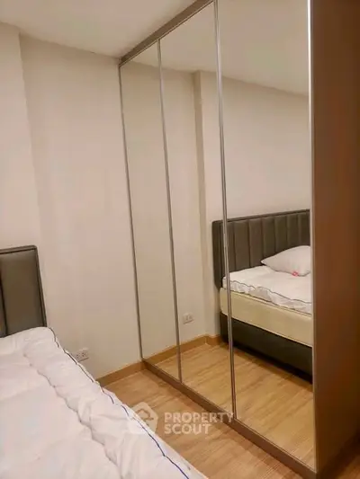 Modern bedroom with mirrored wardrobe and cozy bed in a stylish apartment.