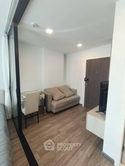 Modern living room with cozy sofa and dining area in open layout apartment.