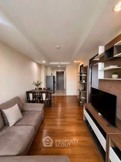 Spacious living room with modern furniture and wooden flooring in a stylish apartment.