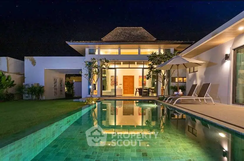 Luxurious villa with stunning pool and modern architecture at night.