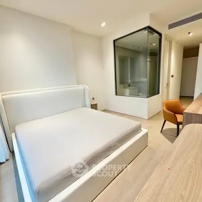 Modern bedroom with sleek design and large window, featuring a comfortable bed and stylish furniture.