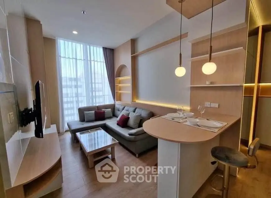 Modern living room with stylish decor and open layout, featuring cozy seating and elegant lighting.