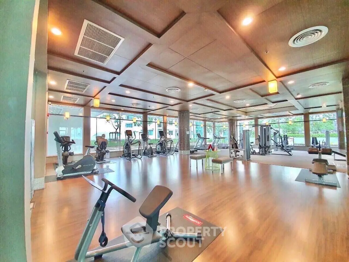 Spacious modern gym with state-of-the-art equipment and large windows for natural light.