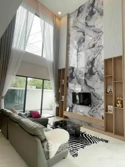 Luxurious modern living room with high ceilings and marble accent wall