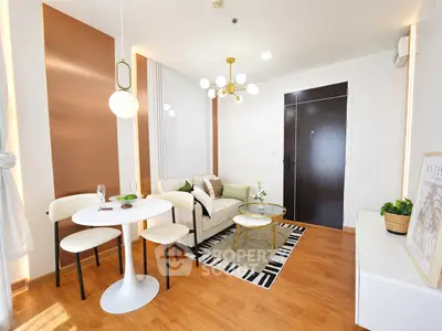Modern living room with stylish decor and wooden flooring, featuring a cozy seating area and elegant lighting.