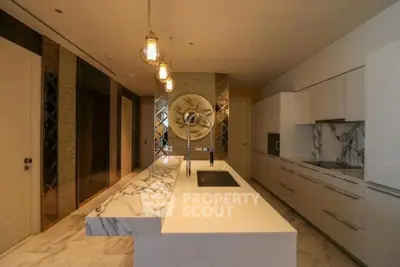 Luxurious modern kitchen with marble countertops and elegant lighting.