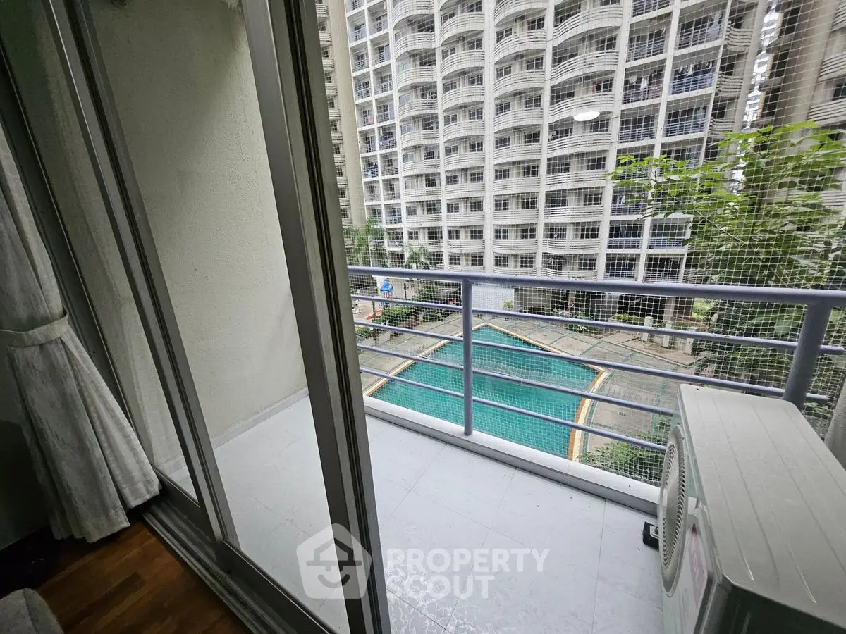 Modern apartment balcony with pool view in urban high-rise building