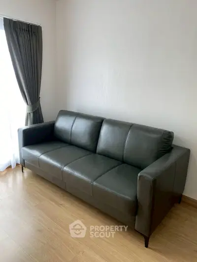Modern living room with sleek black leather sofa and elegant curtains