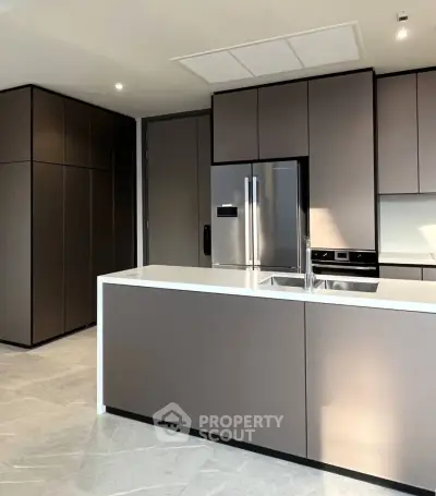 Modern kitchen with sleek cabinetry and stainless steel appliances in a luxury apartment.