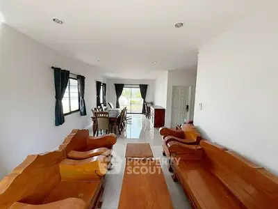 Spacious living room with elegant wooden furniture and natural light.