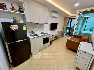 Modern living room with open kitchen and balcony access in stylish apartment.