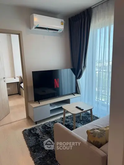 Modern living room with TV, air conditioning, and cozy decor in a bright apartment.