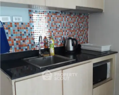Modern kitchen with colorful mosaic backsplash and sleek appliances