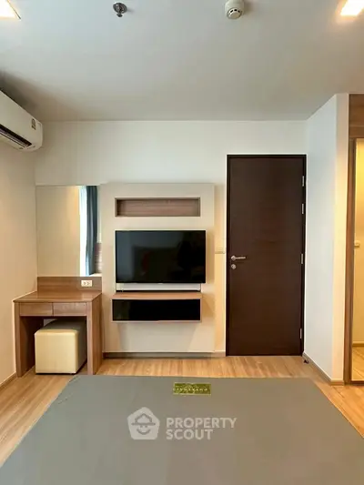 Modern living room with TV, wooden flooring, and stylish decor