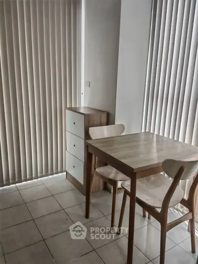 Cozy dining area with wooden table and chairs, perfect for intimate meals.