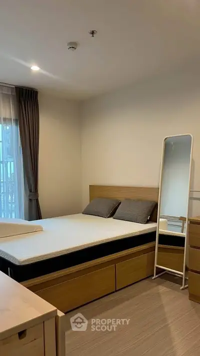 Cozy bedroom with modern furnishings and natural light in a stylish apartment.