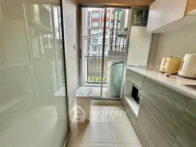 Modern kitchen with sleek cabinetry and balcony view