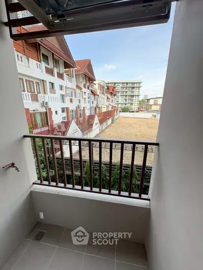 Charming balcony with scenic view of residential buildings and clear blue sky.