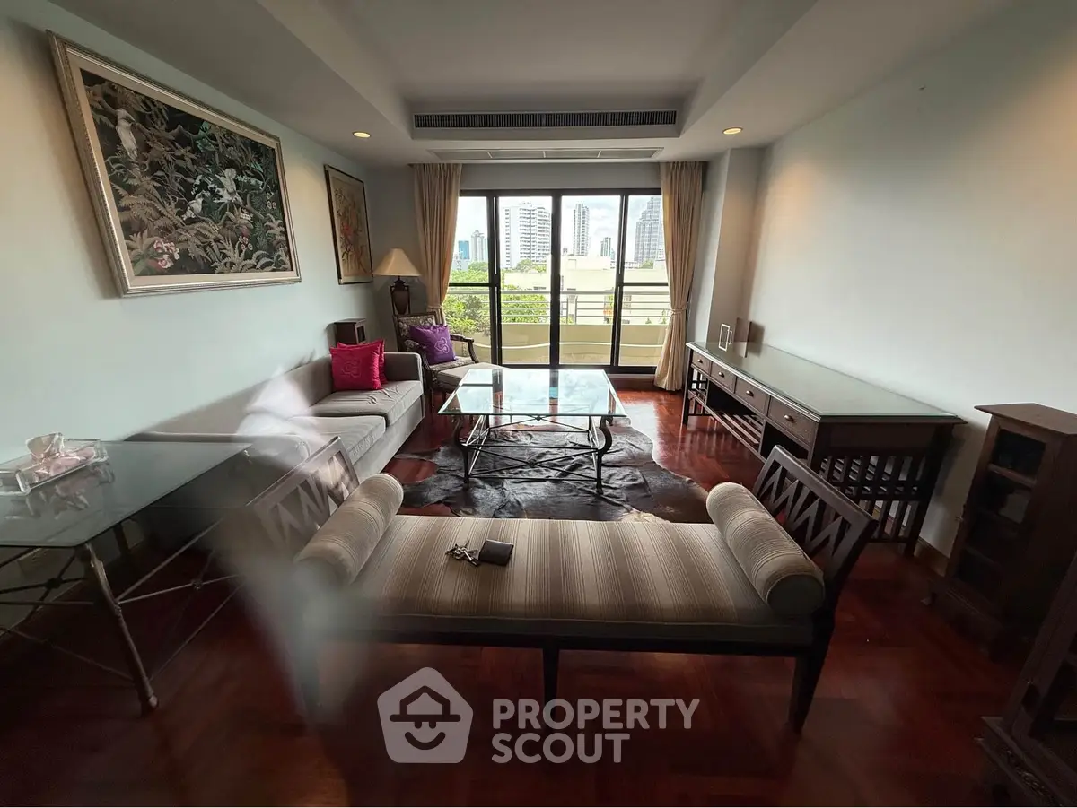 Spacious living room with elegant decor and city view, featuring stylish furniture and large windows.