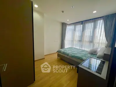 Spacious bedroom with large windows and modern decor, perfect for natural light lovers.