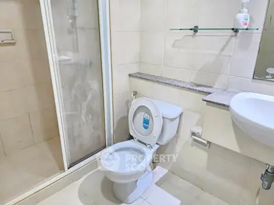 Modern bathroom with shower and toilet in a sleek, tiled design