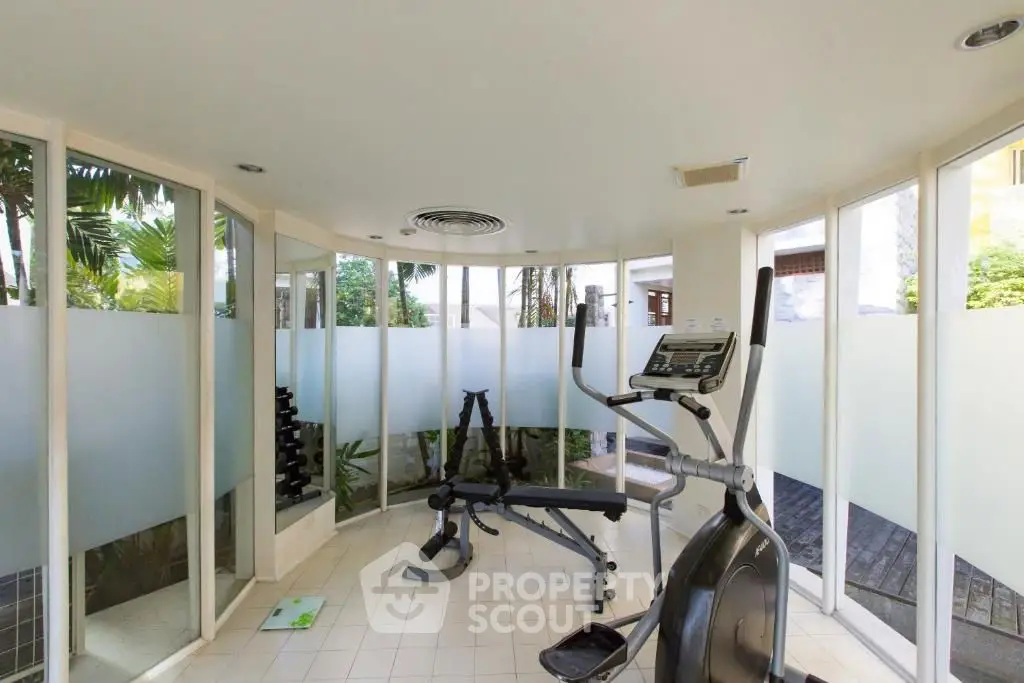 Modern gym with exercise equipment and frosted glass windows in a luxury property.