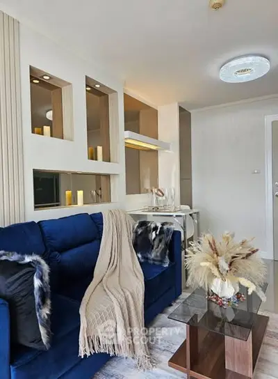 Modern living room with blue sofa, elegant decor, and stylish lighting.