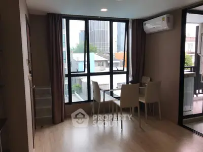 Modern living room with large windows and dining area in urban apartment