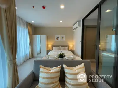 Modern bedroom with cozy decor and natural light, featuring a comfortable bed and stylish furnishings.