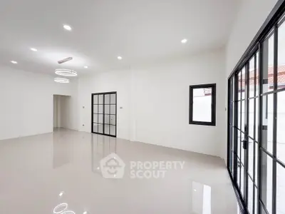 Spacious modern living room with sleek tile flooring and large windows for natural light.