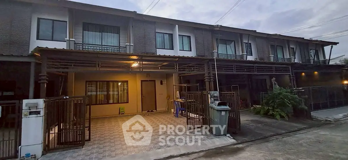 Modern townhouse exterior with gated driveway and contemporary design.