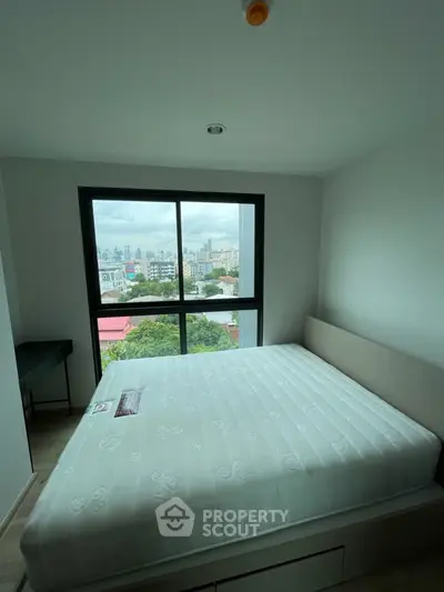 Modern bedroom with large window offering stunning city view, featuring a comfortable bed and sleek design.