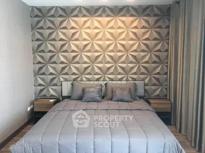 Modern bedroom with geometric accent wall and cozy bedding