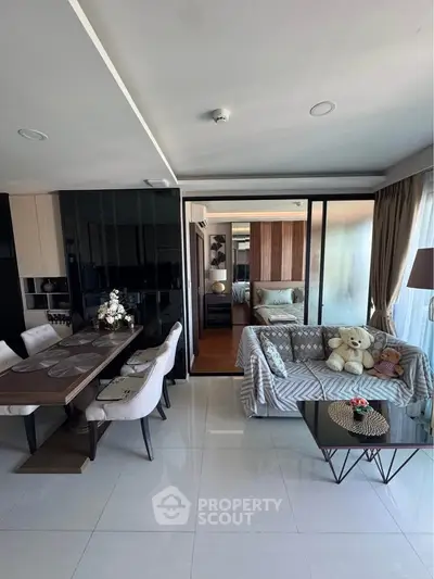 Modern open-plan living room with dining area and cozy decor in a stylish apartment.