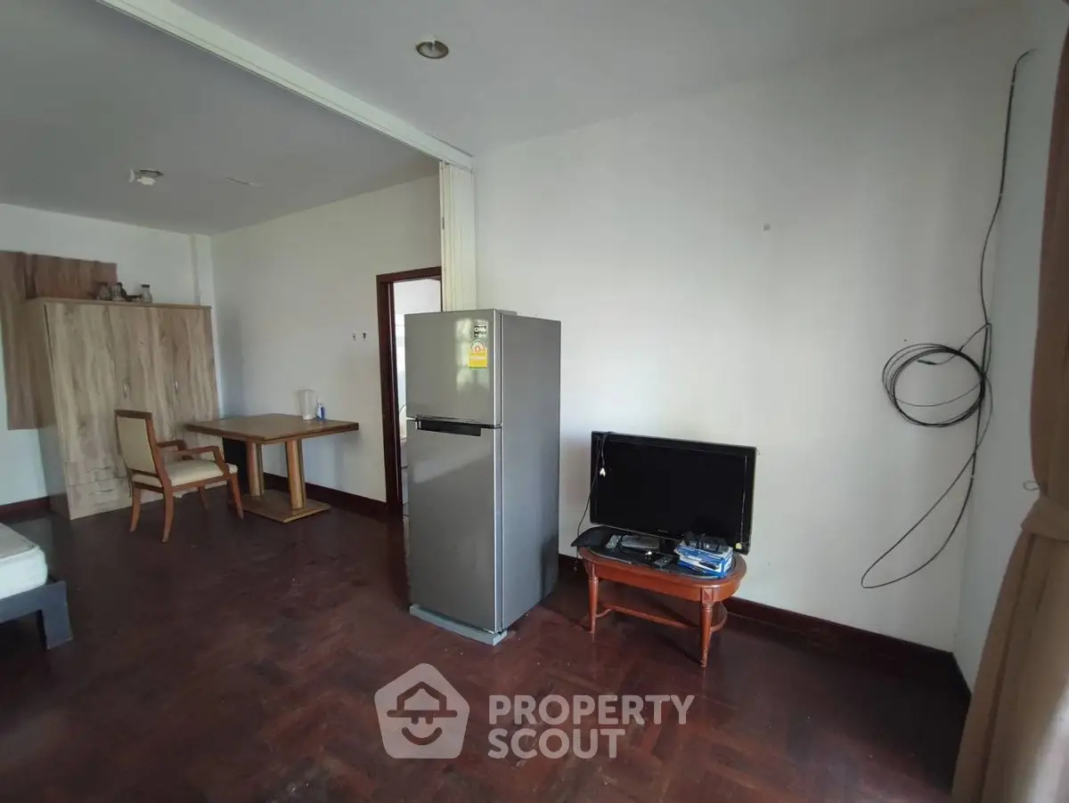 Spacious living area with wooden flooring and modern appliances